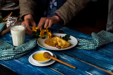 pancakes with honey syrup on a white plate. traditional crepe for pancake week or Shrovetide. crepes with roasted nuts