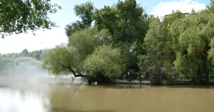 4k Potala in Lhasa,Tibet.lake with willow in lasa park,Smoke transpiration in the lake surface.