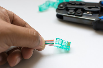 LAN cable with RJ-45 Jack and crimp tool on white background