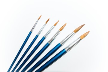 A set of paint brushes. For children in school or a professional artist. White background underlines them. Start to success and create new masterpieces.