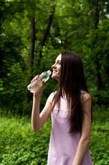 Young smiling woman with bottle of water, outdoors