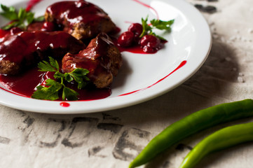 meat with fresh herbs and cherry sauce, ready to eat.