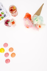 top view of decorative flowers with macaroons and fruity cocktails isolated on white