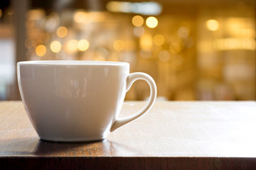 Cup of coffee on wooden table in cafe and restaurant