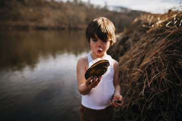 Boy on the beach holding a clam