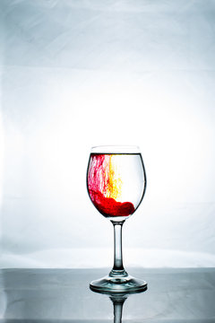 Dark Red Cocktail With Yellow Additive In A Wine Glass On A White Background