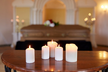 burning candles and coffin in church at funeral