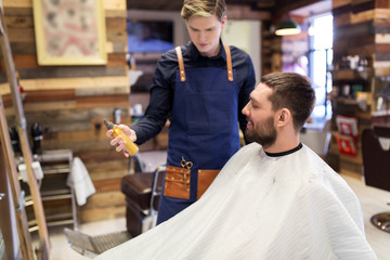 barber showing hair styling spray to male customer