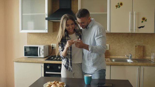 Attractive girl shows pregnancy test result to her boyfriend and surpise him at the kitchen