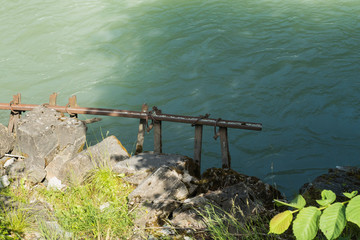 Geländer mit Unkraut am Fluss