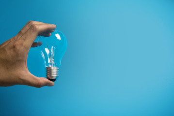 hand pick the idea light bulb on blue color background banner backdrop