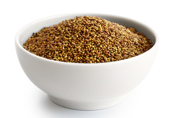 Alfalfa seeds in white ceramic bowl isolated on white.