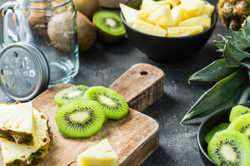 Fresh kiwi and pineapple sliced on wooden board. Smoothie ingredients