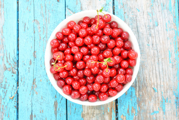  Fresh Cherries Harvesting. Ripe Sweet Cherry Harvest. Cherries in color bowl on wooden background. 