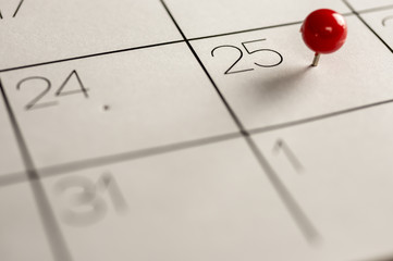 Close up shot of a red pin on the 25th day on calendar