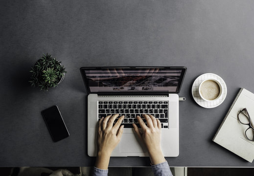Hands of cropped unrecognisable businesswoman typing on her laptop.