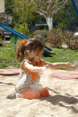 Kid girl playing in a sandpit