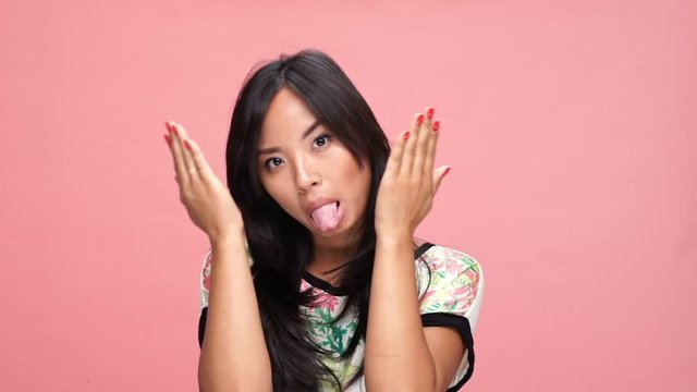 Young asian woman showing different emotions over pink background