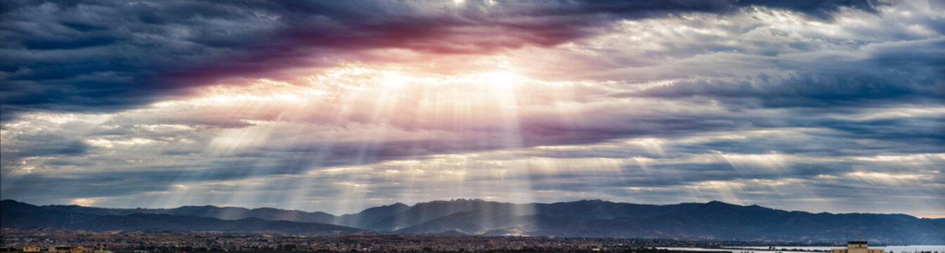 Beam of light through the clouds on the mountains - Rays of light shining through dark clouds , dramatic sky with cloud