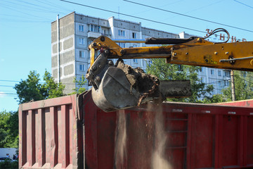 Road repair, excavator cleans old curbs