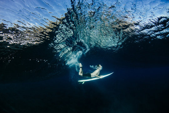 Side view of a surfer Duck Diving under a wave in ocean surf, Hawaii, USA