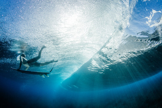 Man duck diving under a wave with surfboard