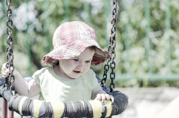 Happy baby with her mother in a swing