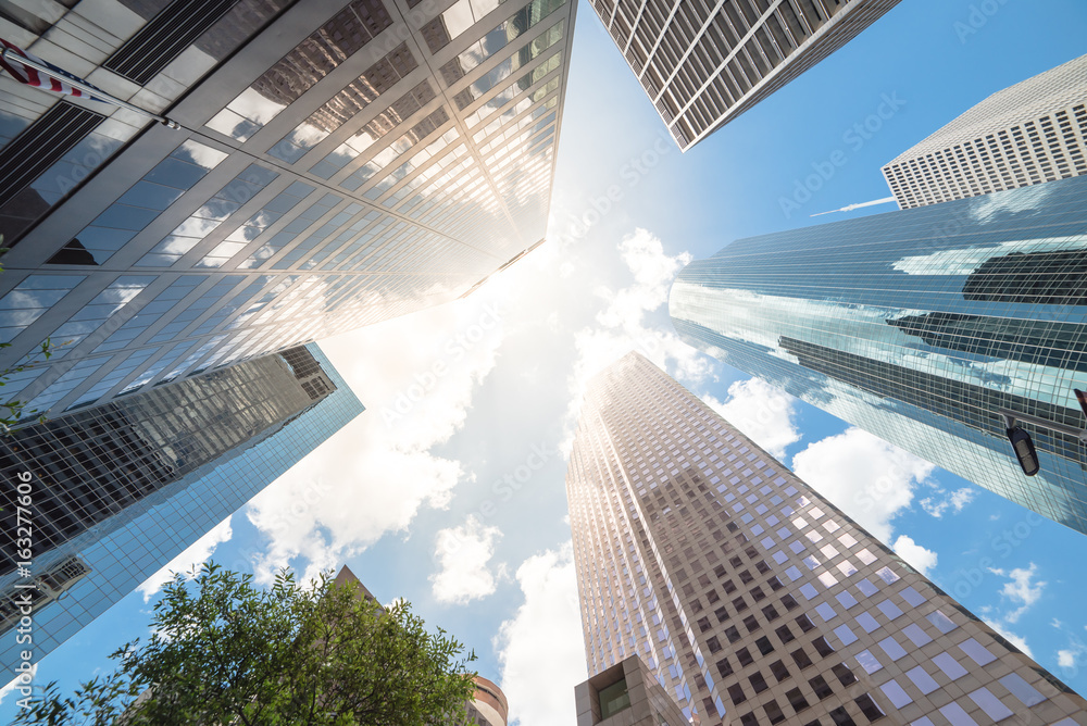 Wall mural Upward view of skyscrapers against a cloud blue sky in the business district area of downtown Houston, Texas, US.