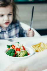 Kid in a restaurant and healthy food.