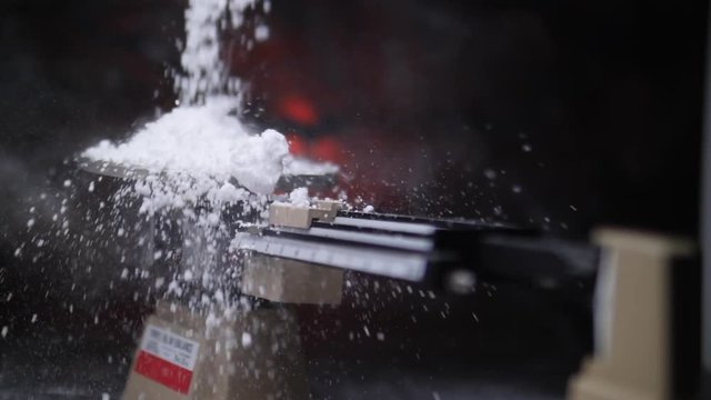 LARGE AMOUNT OF ILLEGAL DRUG RAINS DOWN ON A SCALE, IN SLOW MOTION