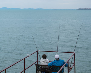 Old couple sitting and fishing together