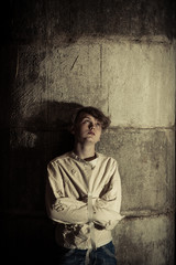 Sad child looking up while tied in straight jacket