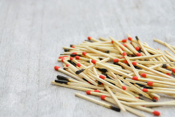 tas d'allumettes rouges et brûlées sur fond bois