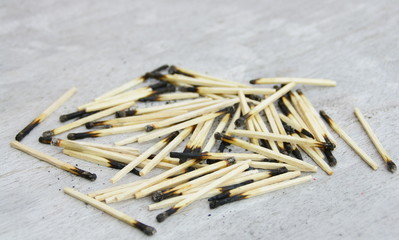 tas d'allumettes brûlées sur fond bois
