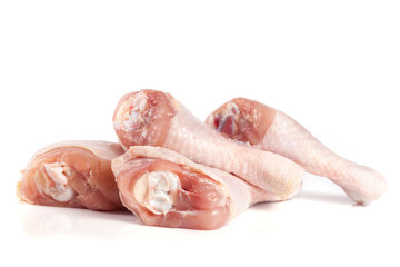 four raw chicken drumsticks isolated on white background