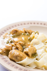 Flat lay chicken breasts with sauce and pasta.