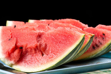 Slices of watermelons on the table with black background.