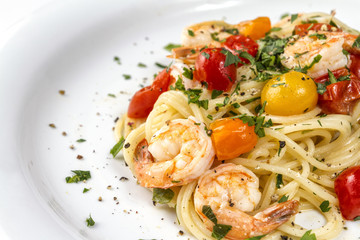 Seafood. Spaghetti pasta with prawns or shrimps with mixed colours cherry tomatoes fresh parsley and pepper.