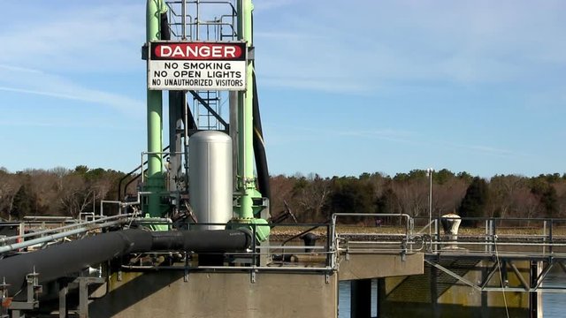 Fuel tanker docking/pumping station for electric power plant on cape cod canal with danger sign