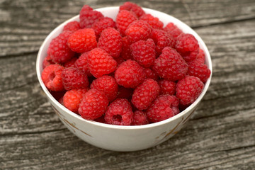 fresh sweet raspberry plate on wooden table 
