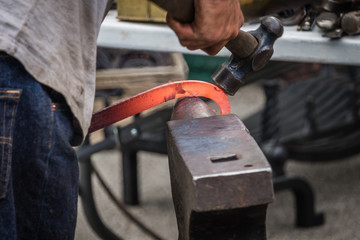 A blacksmith hammering hot iron
