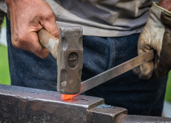 A blacksmith hammering hot iron