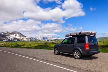Fototapeta na wymiar SUV on road by Glacier National Park