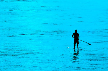 Silhouette of a man on SUP off Southern California beach