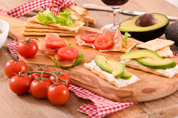Crackers with ham and avocado. 