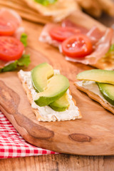 Crackers with ham and avocado. 