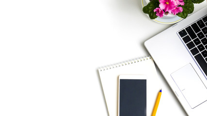Modern white office computer Desk, mobile with a black screen, laptop, flowers. Top view with copy space, flat lay.