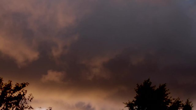 Orange pink storm cloud squall comes under blue sky