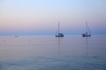 Żaglówki na morzu przed wschodem słońca, na wyspie Rodos w Grecji. - obrazy, fototapety, plakaty