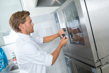 Chef at door of industrial oven